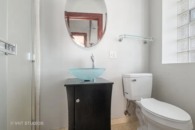 a white toilet sitting next to a bathroom sink