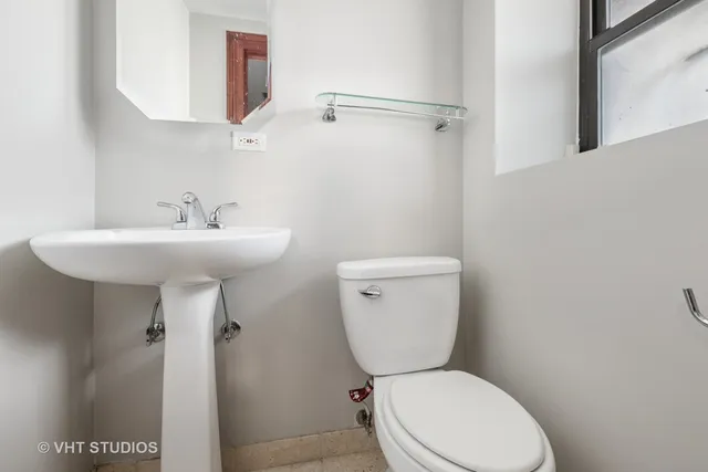 a bathroom with a toilet sink and mirror