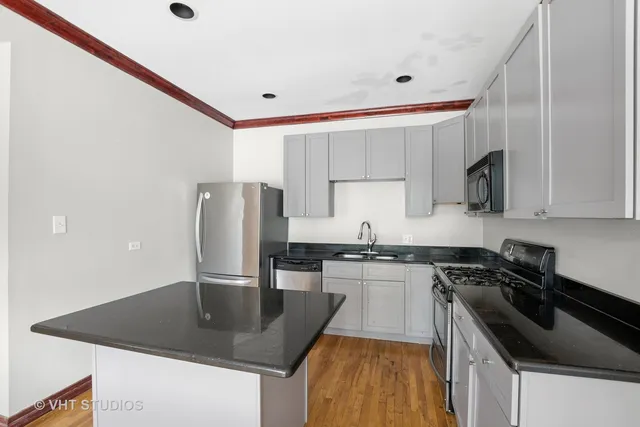 a kitchen with stainless steel appliances granite countertop a sink a stove and a refrigerator