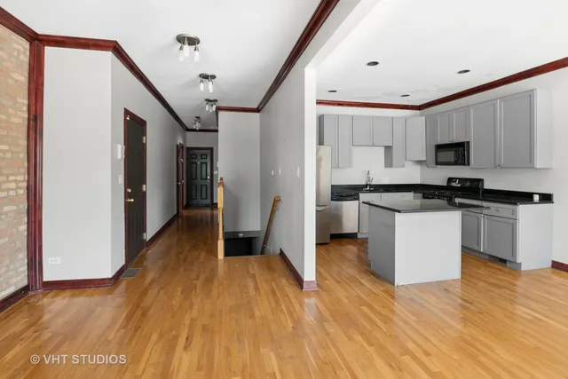 a kitchen with stainless steel appliances a refrigerator sink and white cabinets