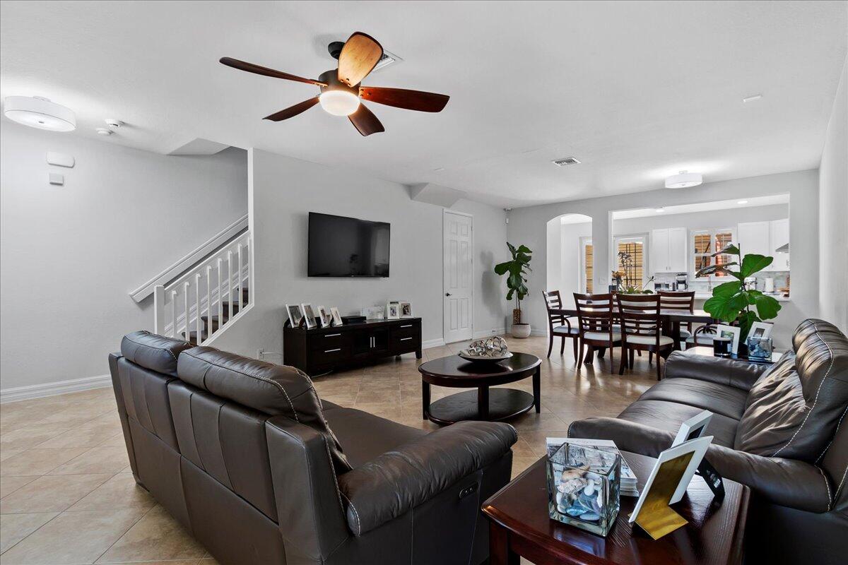 251 Edenberry Avenue Jupiter, FL 33458 - Photo 9 of 31 a living room with furniture a ceiling fan a flat screen tv and a window