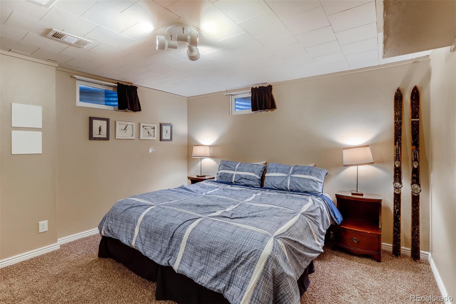 3375 Wright Street Wheat Ridge, CO 80033 - Photo 20 of 26 a bedroom with a bed a mirror and lamp
