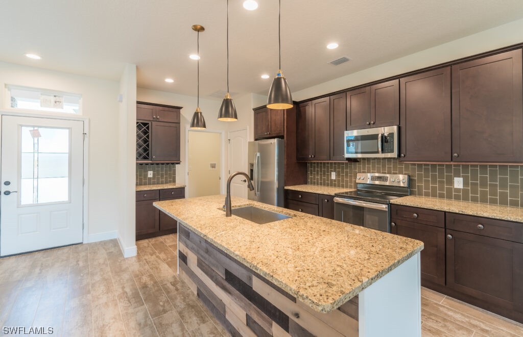 a kitchen with kitchen island granite countertop wooden cabinets and refrigerator