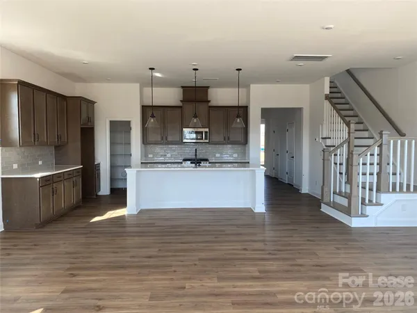 a large kitchen with stainless steel appliances kitchen island granite countertop a large counter top and a stove top oven