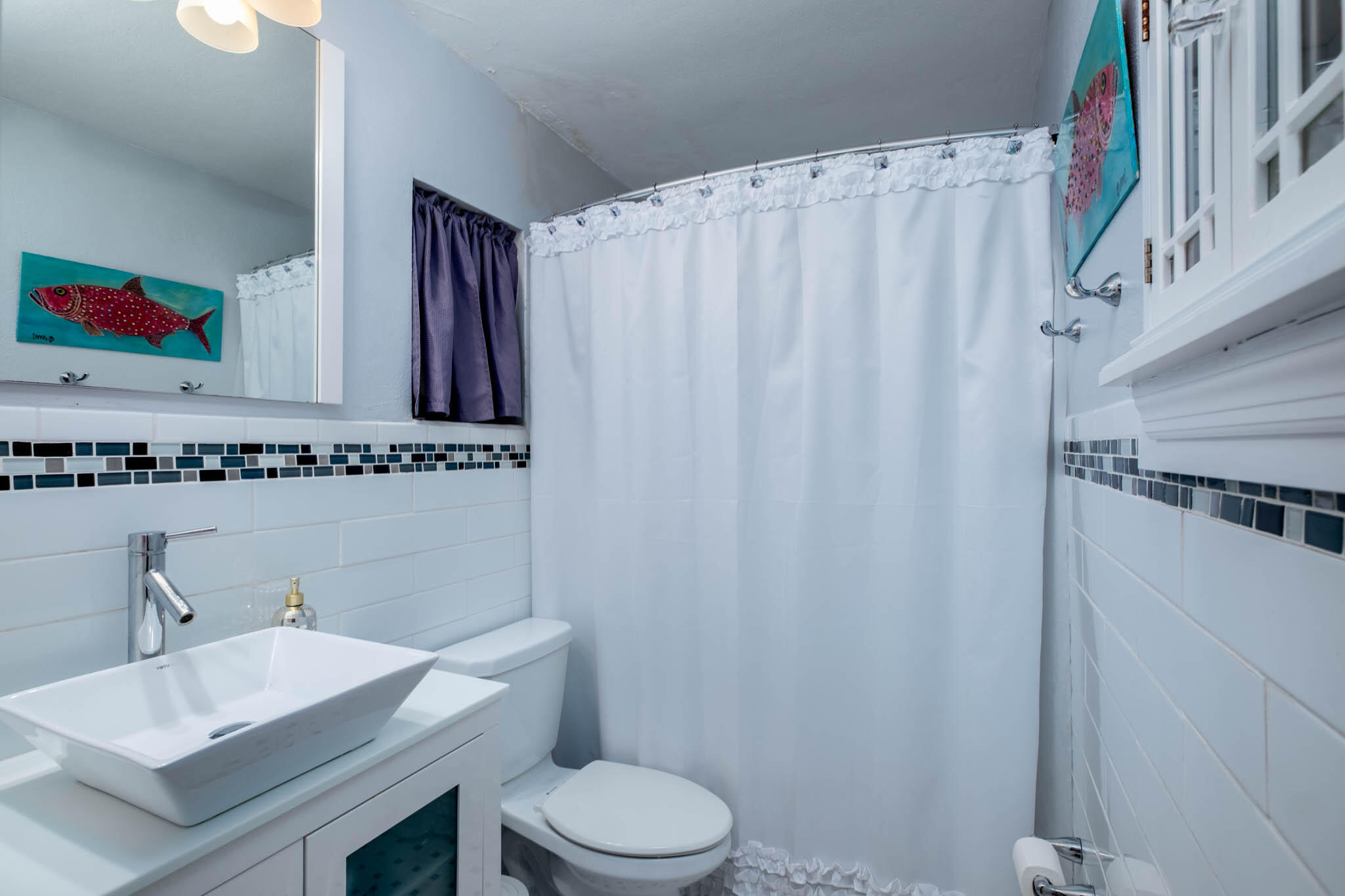 153 Apache Street Tavernier, FL 33070 - Photo 13 of 20 a bathroom with a sink a toilet and shower curtain