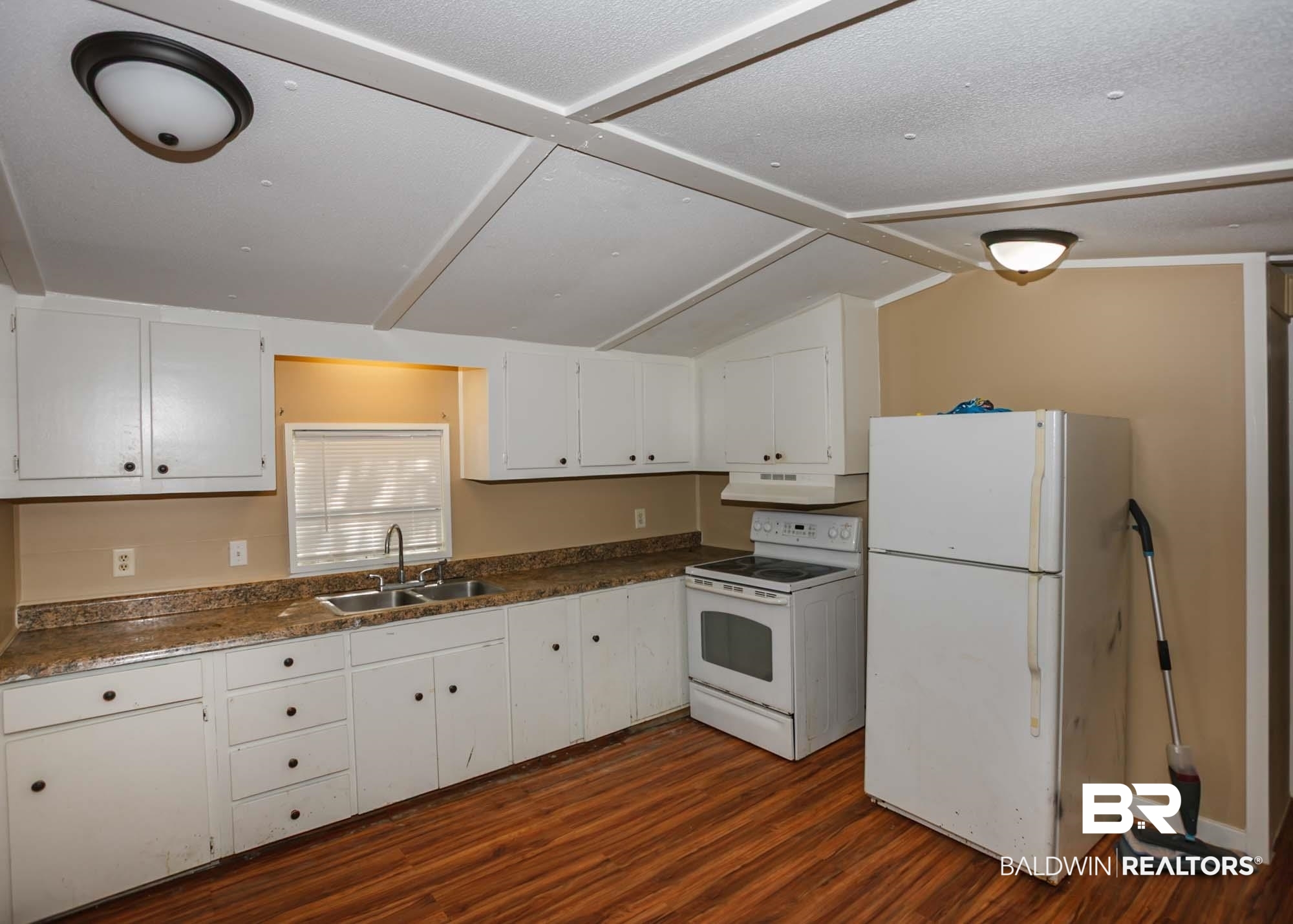 11998 Workman Avenue Foley, AL 36535 - Photo 36 of 59 Kitchen featuring white appliances, dark wood-type flooring, white cabinets, dark countertops, and vaulted ceiling