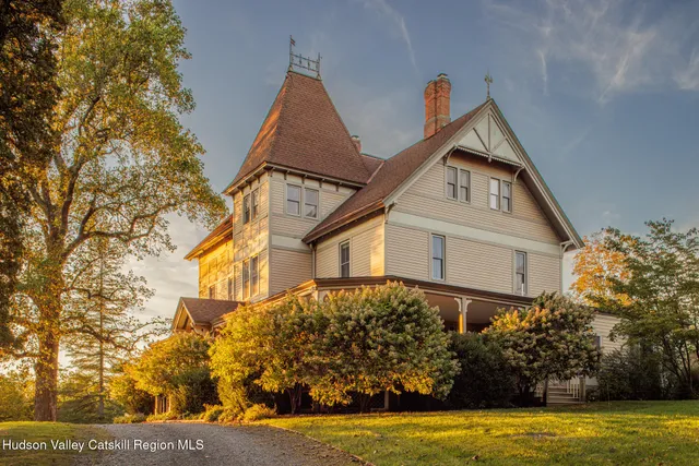 a view of a brick house with large windows and a yard