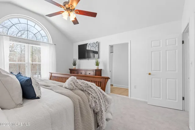 a bedroom with a large bed a chandelier and a flat tv screen