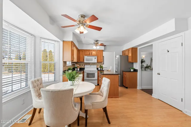 a dining room with furniture a livingroom view and wooden floor