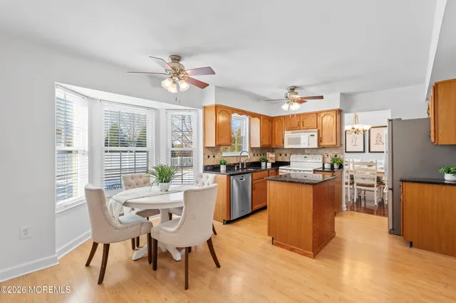 a dining room with furniture a kitchen view and chandelier