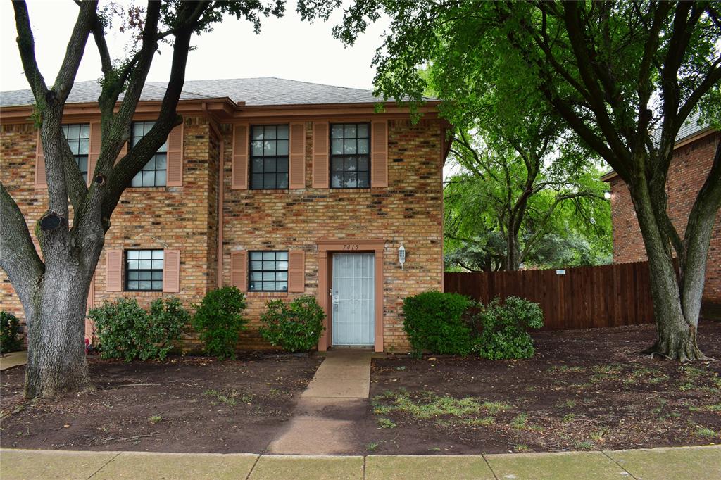 a front view of a house with yard and trees