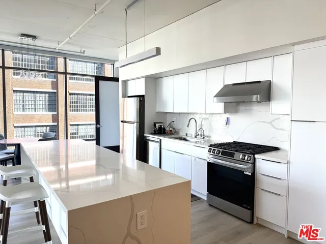 a kitchen with stainless steel appliances granite countertop a stove a sink and a refrigerator