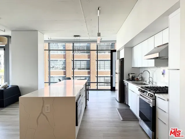 a large kitchen with stainless steel appliances a lot of counter space and a window