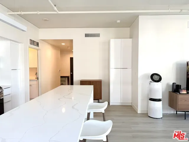 a large white room with wooden floor and furniture