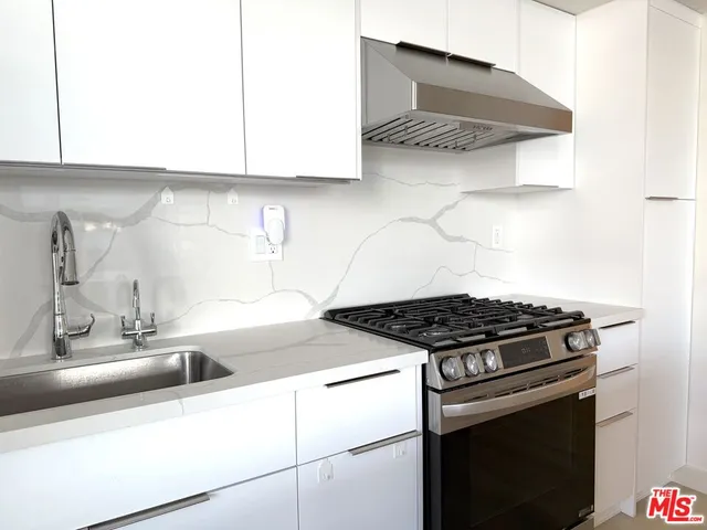a kitchen with granite countertop a stove and a sink