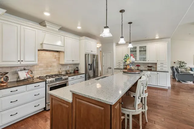 a kitchen with stainless steel appliances granite countertop a refrigerator and cabinets
