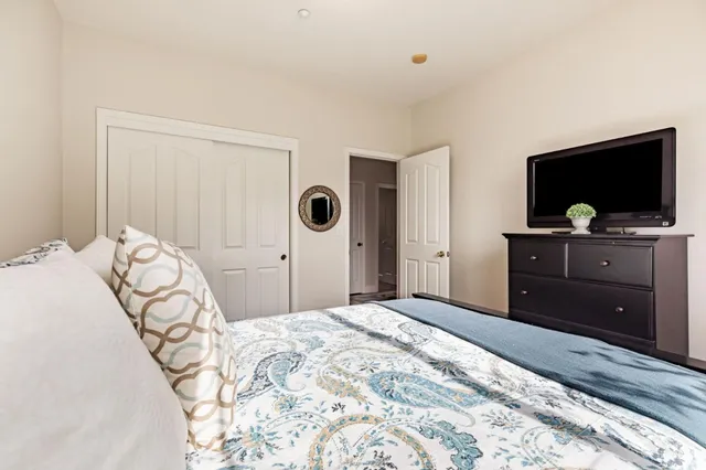 a bathroom with a granite countertop sink a toilet a mirror and shower