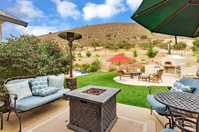 a view of a chairs and table in backyard with a potted plant