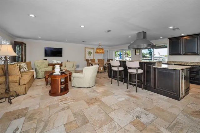 a kitchen with stainless steel appliances granite countertop a table chairs sink and cabinets