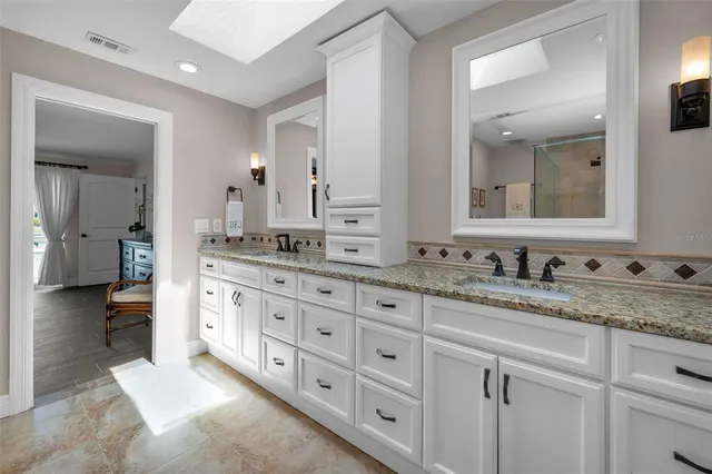 a en suite bathroom with a double vanity sink and mirror