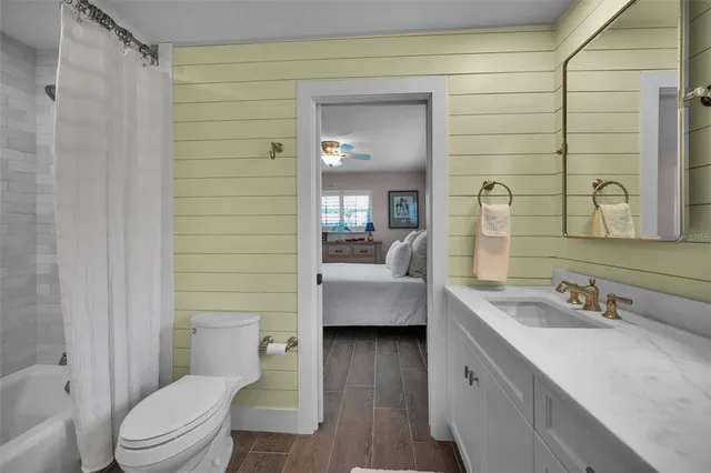 a kitchen with stainless steel appliances granite countertop a sink a stove a refrigerator and white cabinets