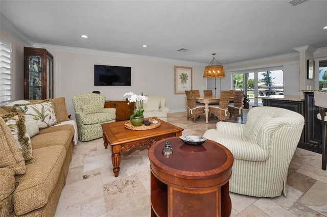 a living room with furniture kitchen view and a wooden floor