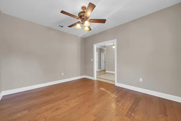 a kitchen with kitchen island granite countertop a stove a sink a oven a dining table and chairs with wooden floor