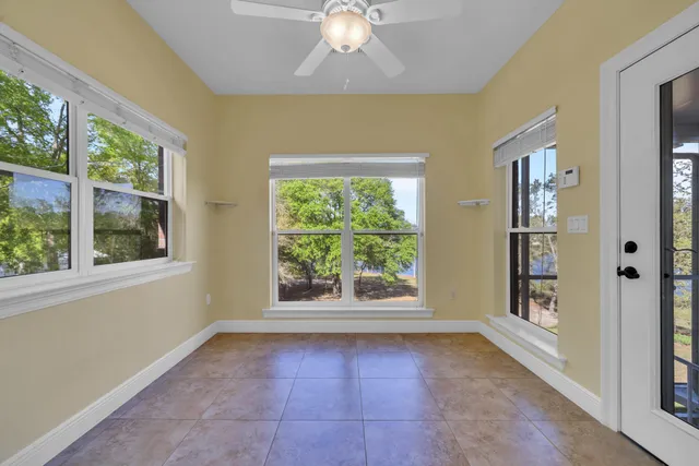 an empty room with a ceiling fan and window