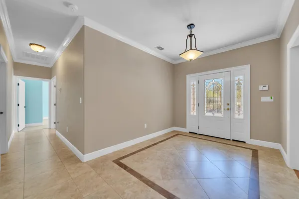 an empty room with windows and ceiling fan