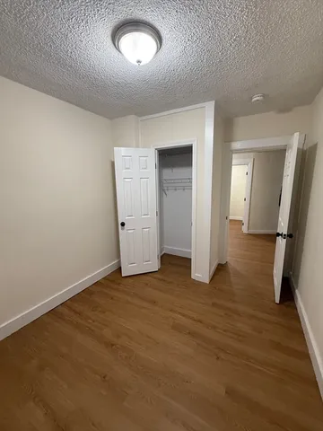 an empty room with wooden floor and mirror