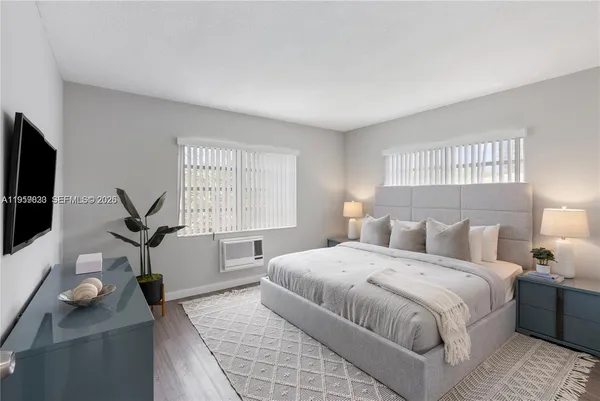 a bedroom with a balcony a bed and a flat screen tv