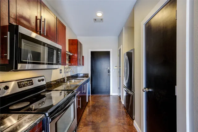 a kitchen with stainless steel appliances a stove a microwave and a refrigerator