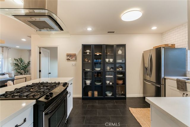 a kitchen with stainless steel appliances granite countertop a refrigerator and a stove