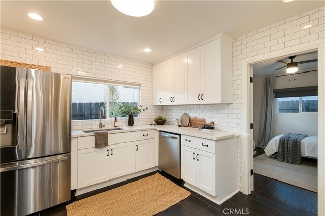 a kitchen with white cabinets and white appliances
