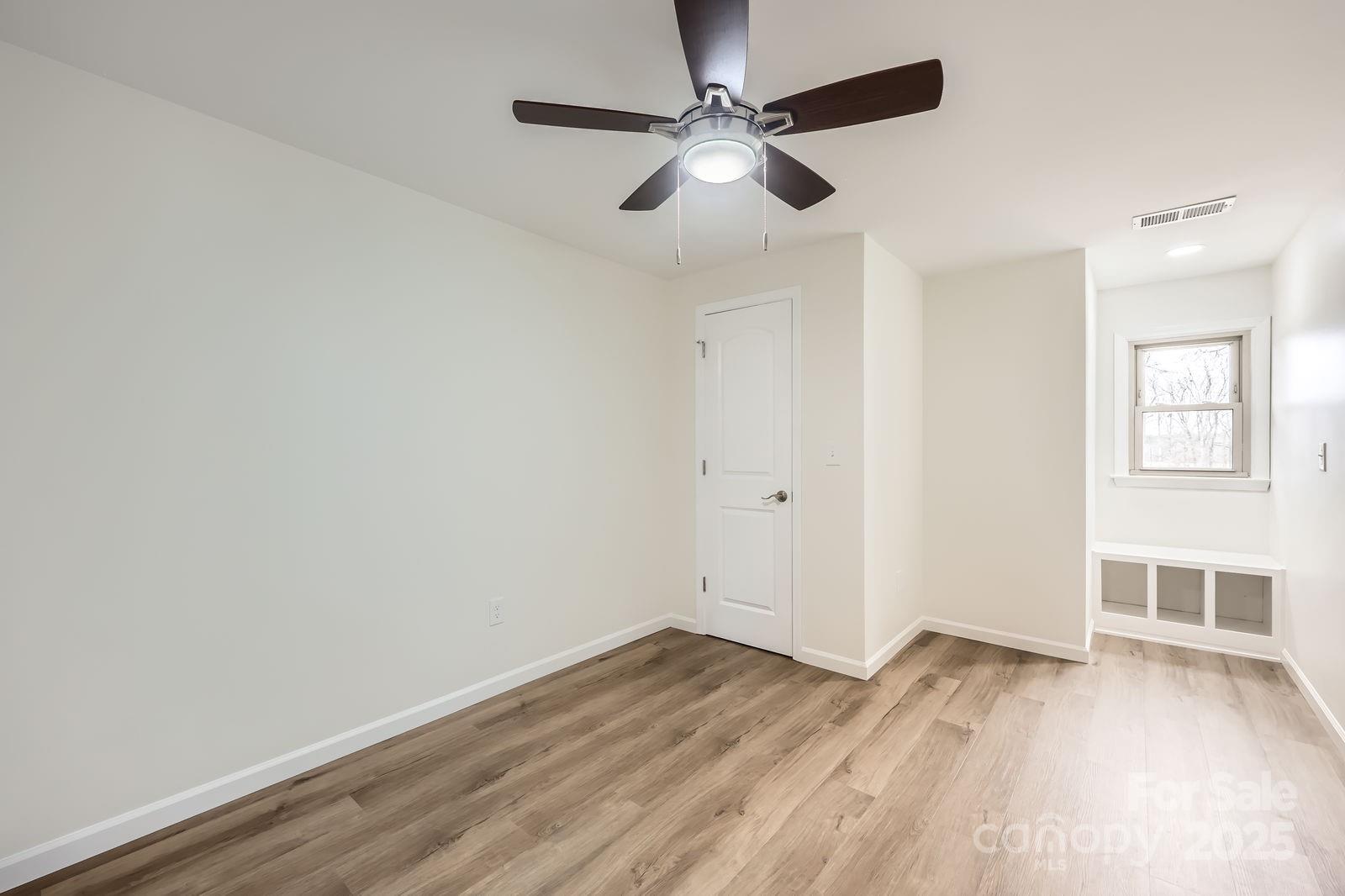 3225 Liberty Road Gold Hill, NC 28071 - Photo 14 of 24 an empty room with wooden floor chandelier fan and windows