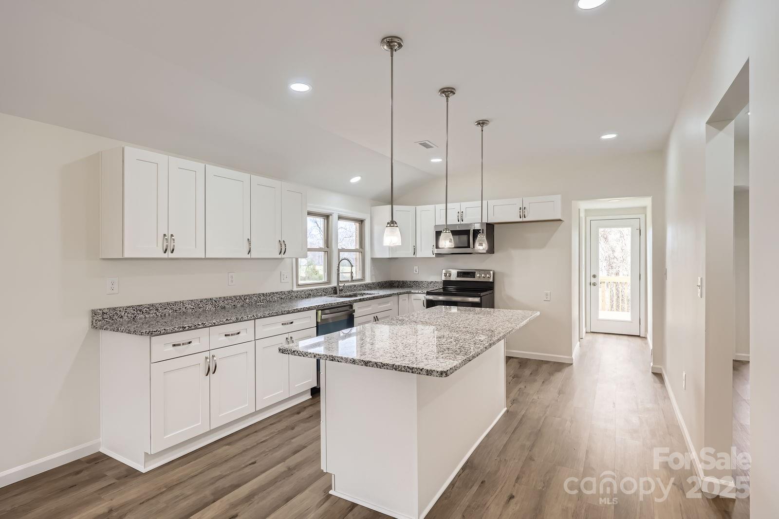 3225 Liberty Road Gold Hill, NC 28071 - Photo 5 of 24 a kitchen with stainless steel appliances granite countertop a sink a stove a refrigerator and white cabinets