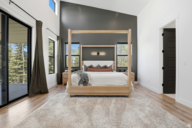 1000 West Upper Cove Road Park City, UT 84098 - Photo 16 of 63 Vaulted ceiling bedroom with a dark accent wall, and a sliding glass door to an exterior balcony