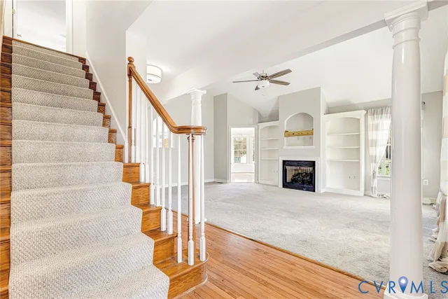a view of a livingroom with wooden floor and a fireplace