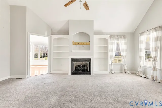 an empty room with fireplace and windows