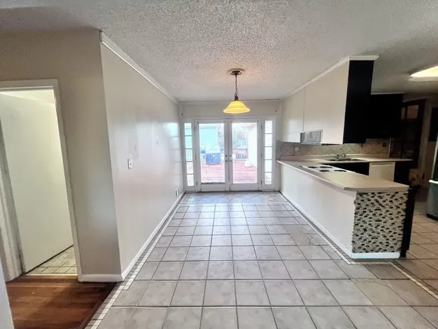 a kitchen with a sink a stove cabinets and a counter top space