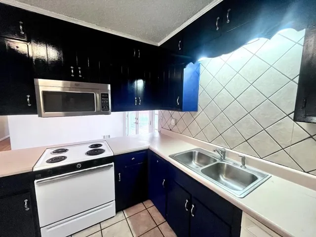 a kitchen that has a sink and a stove in it