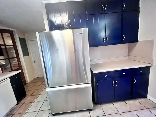 a view of a kitchen with refrigerator and cabinets