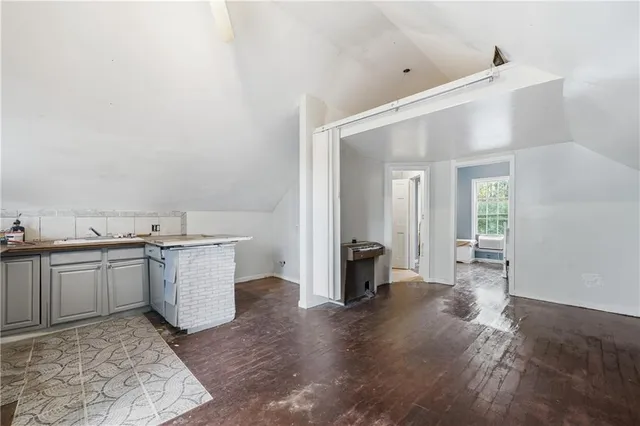 a view of a kitchen with a sink and dishwasher a stove with wooden floor