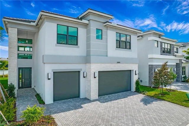 a front view of a house with yard and parking