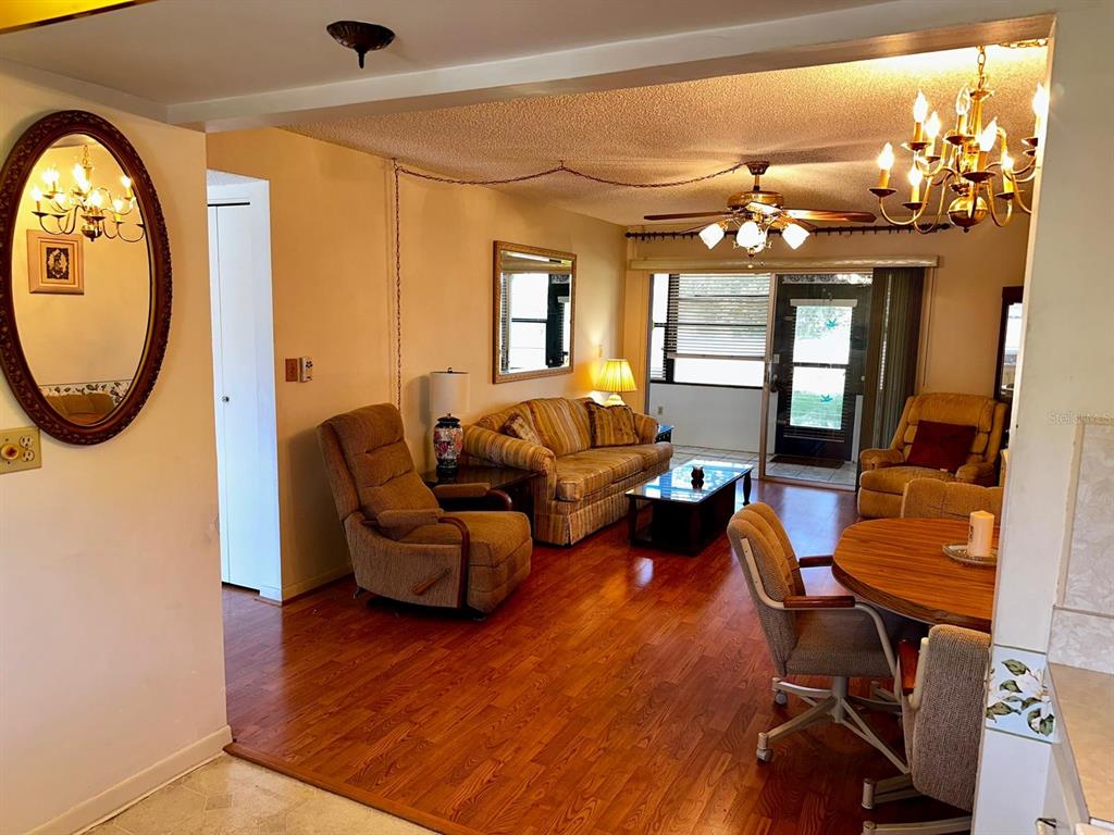 7040 Cognac Drive, Unit 1 New Port Richey, FL 34653 - Photo 16 of 45 a living room with furniture a chandelier and a large window