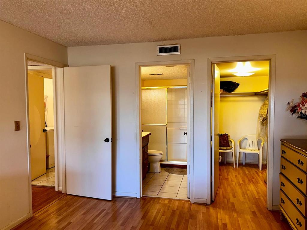 7040 Cognac Drive, Unit 1 New Port Richey, FL 34653 - Photo 30 of 45 a view of a hallway with wooden floor and a bathroom
