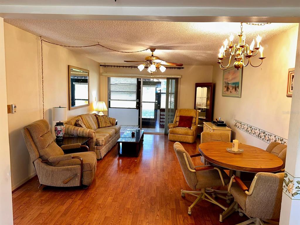 7040 Cognac Drive, Unit 1 New Port Richey, FL 34653 - Photo 7 of 45 a living room with furniture and a chandelier