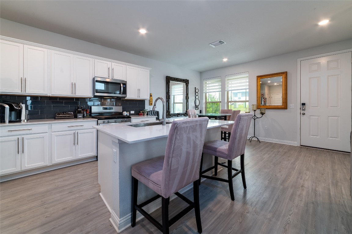 8505 Leroi Drive, Unit 358 Austin, TX 78744 - Photo 25 of 37 a kitchen with microwave a sink and chairs