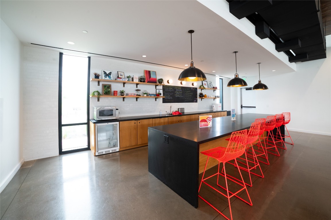 8505 Leroi Drive, Unit 358 Austin, TX 78744 - Photo 28 of 37 a kitchen with stainless steel appliances kitchen island granite countertop a sink a counter space and cabinets