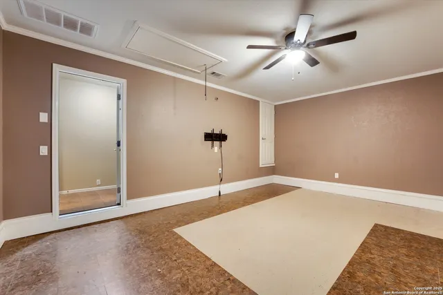 an empty room with windows and fan